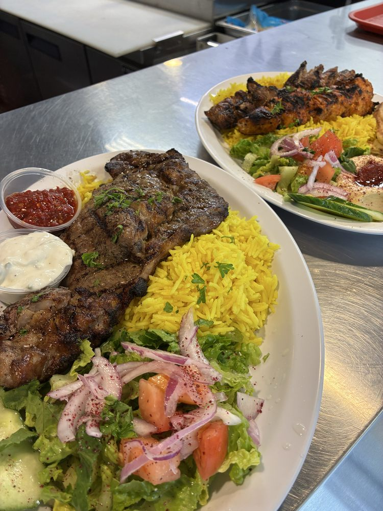 Fresh grilled meat platters with yellow rice and salad