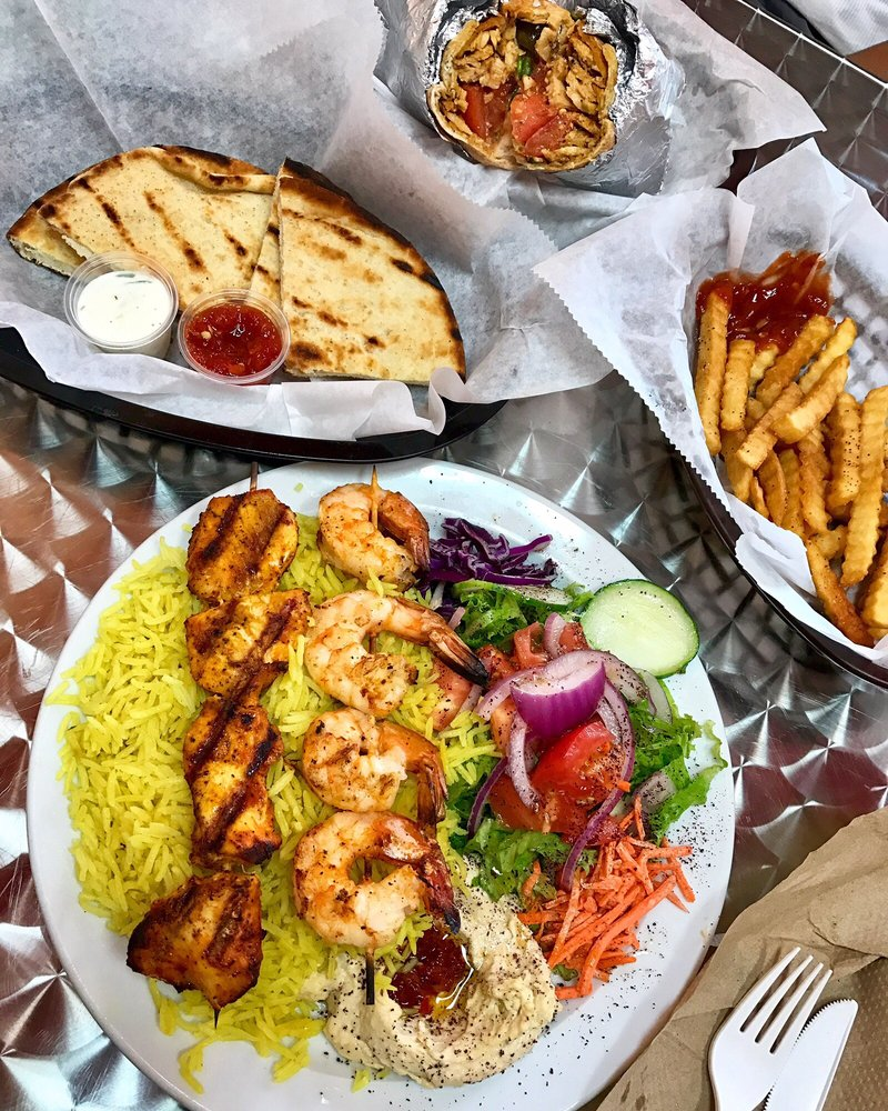 Shrimp and chicken kabob platter with rice, hummus and salad